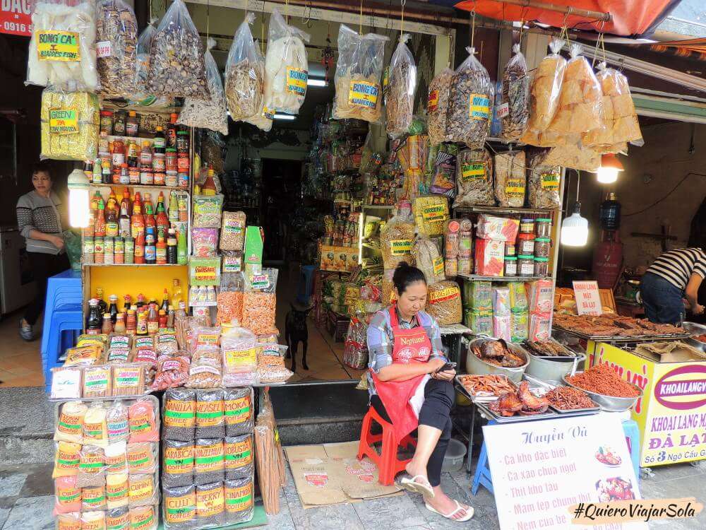 Una señora a la puerta de su tienda en Hanoi