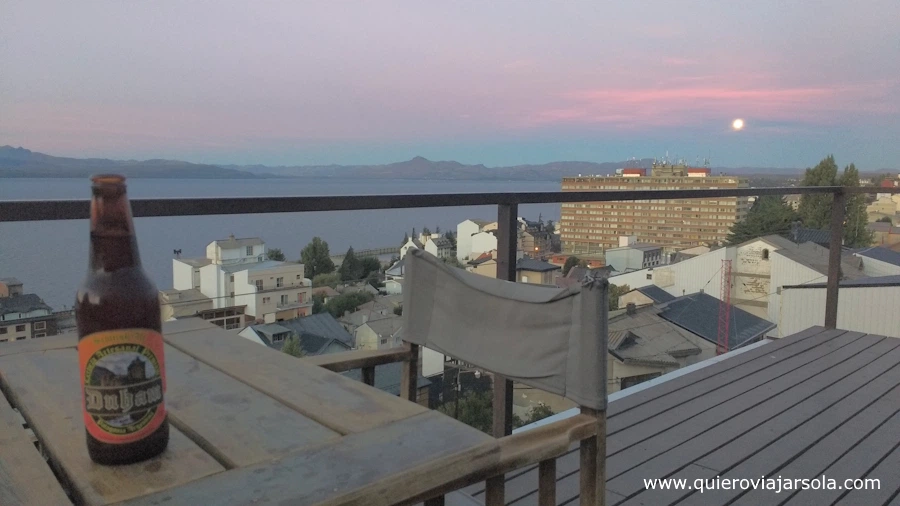 Mi cerveza en la terraza del hostel de Bariloche al atardecer