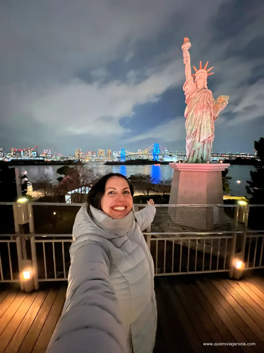 Yo disfrutando de Tokio iluminado desde Odaiba y la Estatua de la Libertad al caer la noche