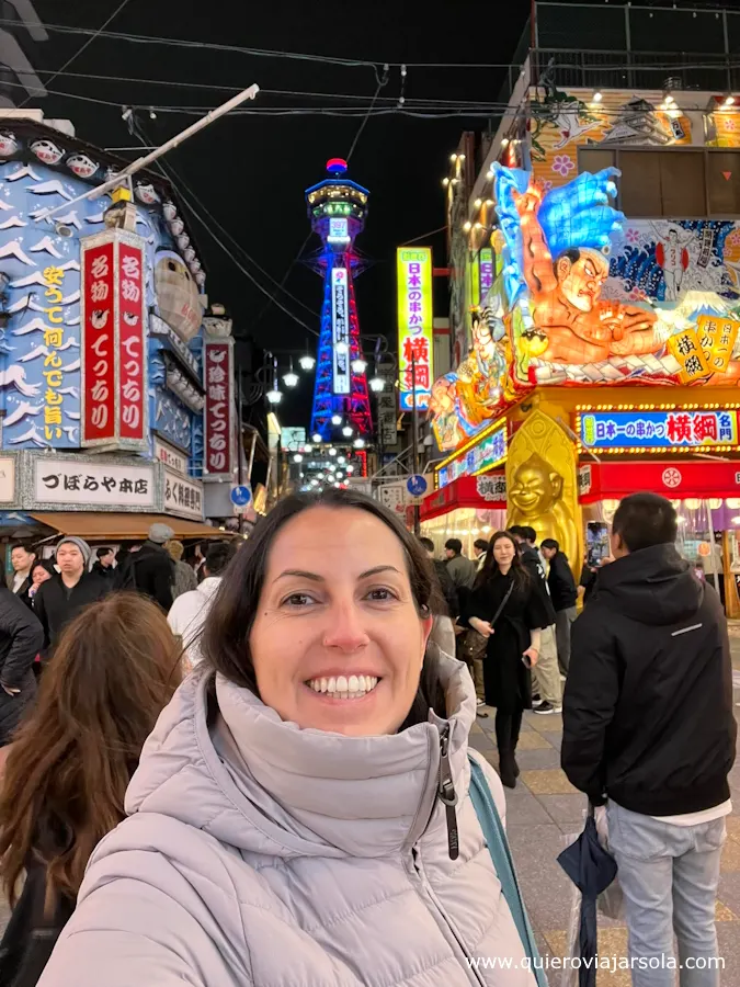 Yo en Shinsekai con la torre Tsutenkaku detrás de noche