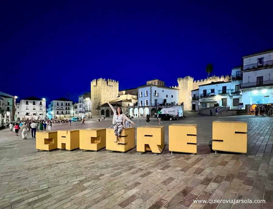 Yo en las letras de Cáceres en la Plaza Mayor de la ciudad al anochecer